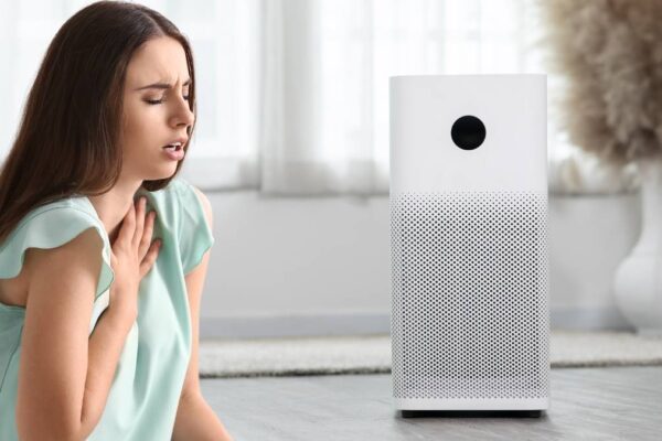 Air purifier in front of girl with trouble breathing