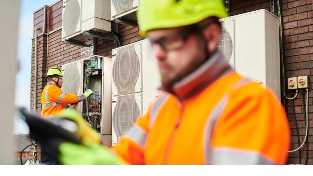 Workers checking on air conditioner