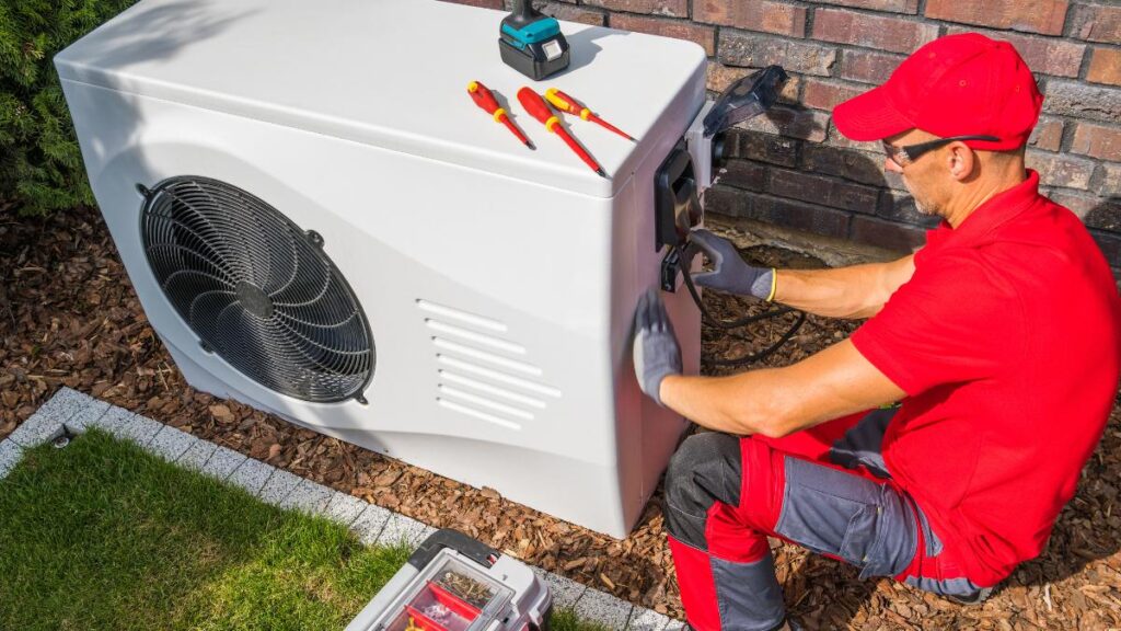 guy in red checking on ac