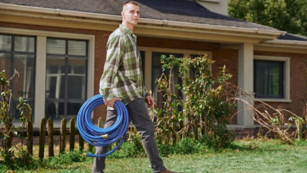 man carrying garden hose