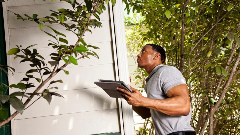man checking house exterior