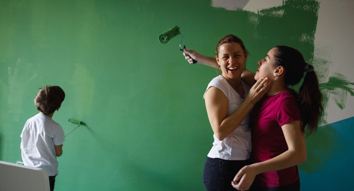 Family having fun painting the room