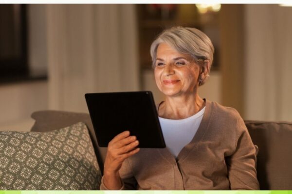 Senior sitting at home with tablet in hand