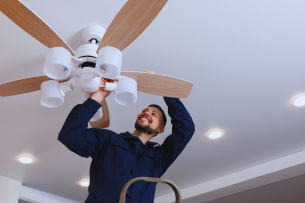 A man working on a ceiling fan