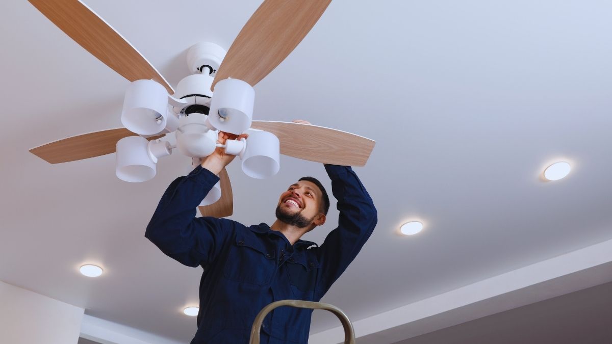 A man working on a ceiling fan