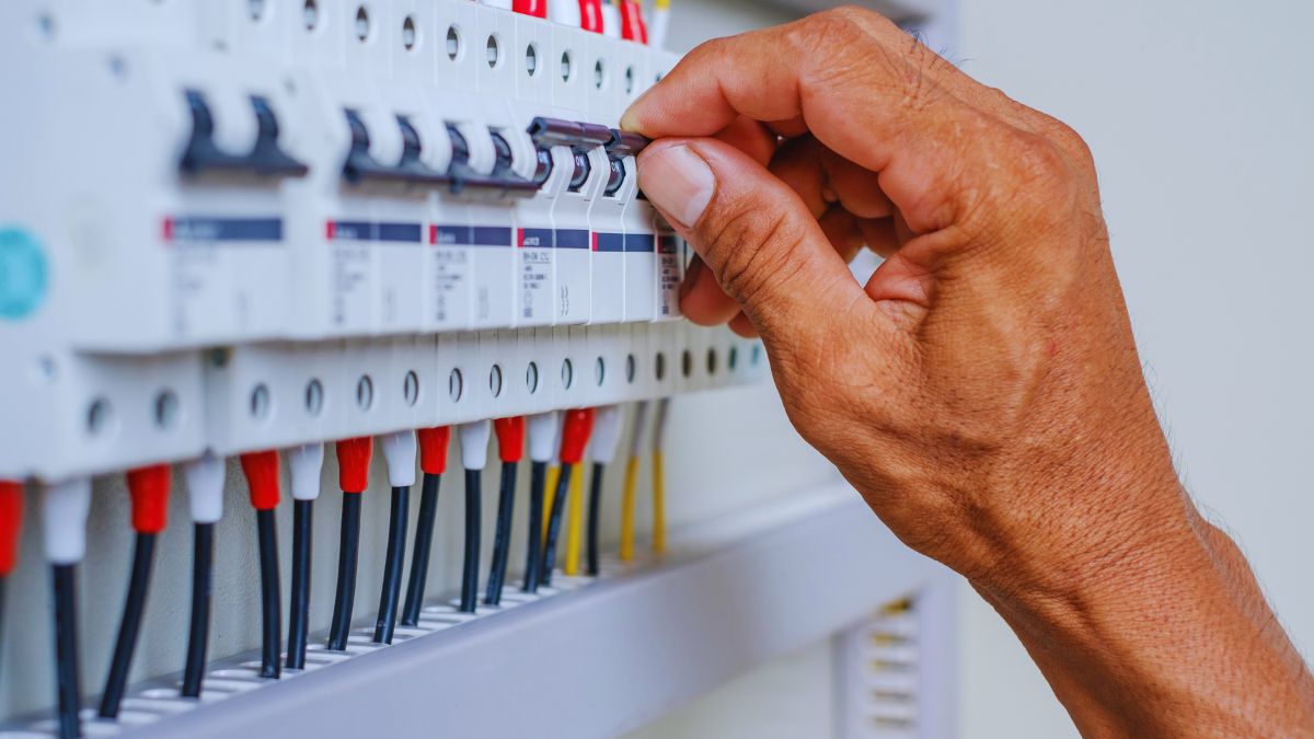 a person's hand checking on a circuit breaker