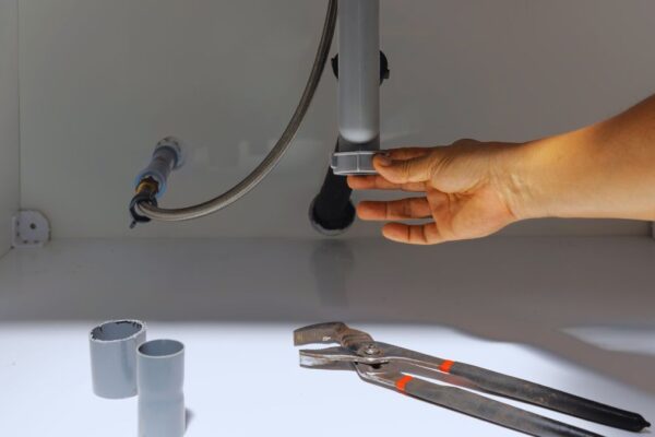 person's hand checking on a drain