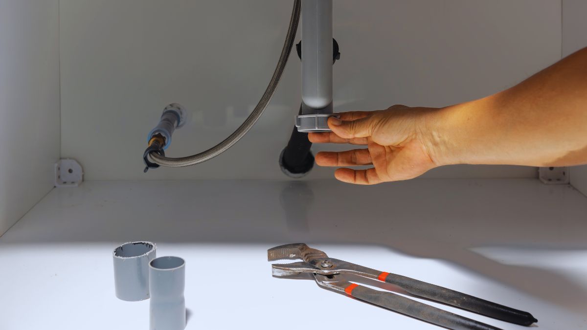 person's hand checking on a drain